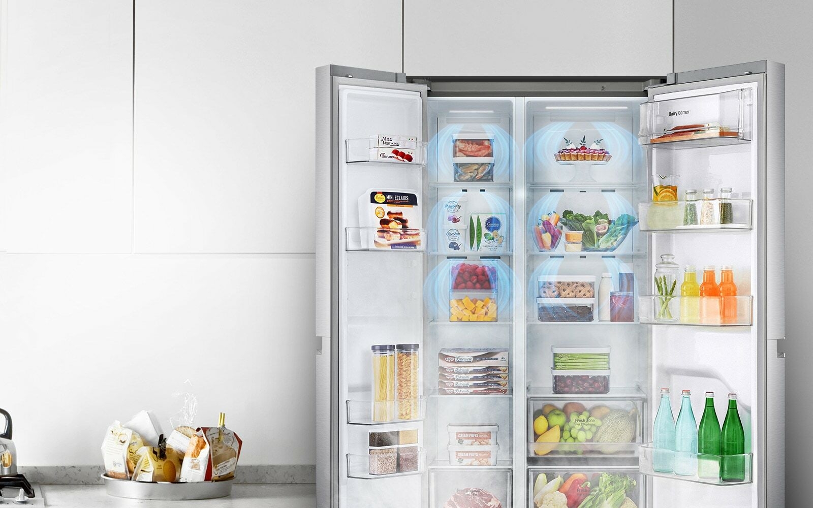 A front view of the refrigerator with the two front doors wide open showing a full stocked fridge. Blue clouds of mist are shown going down over all of the produce.