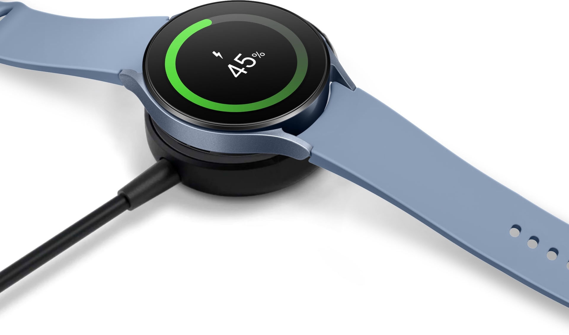 A Sapphire Galaxy Watch5 on top of a wireless charger in black.