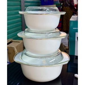 a set of three white serving bowls with glass lids. White