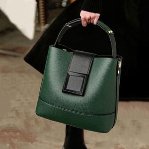 Elegant solid-color faux leather bucket bag with adjustable shoulder strap - Women's multi-functional crossbody and tote bag, lightweight with zipper closure.